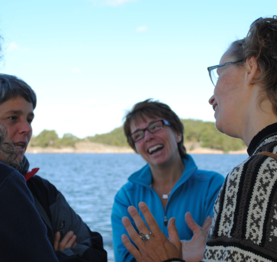 Personer pratar vid vatten. 