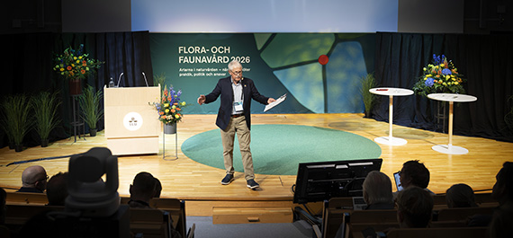 En man i kavaj står på konferensscen.
