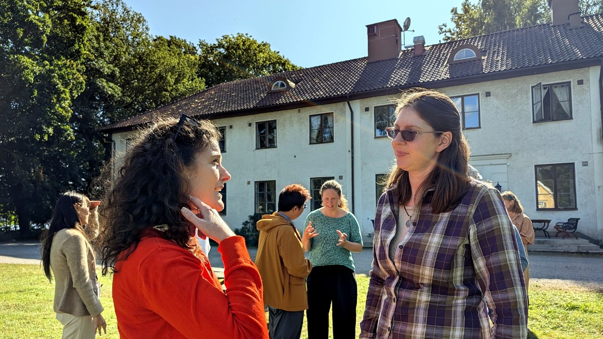 Attendees outdoors talking to each other. Photo.