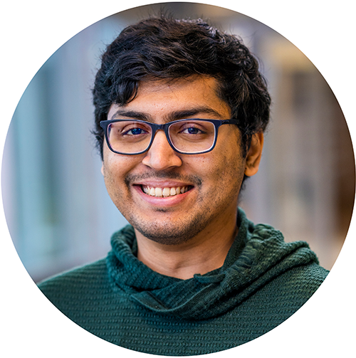 A smiling man with a green sweater. Photo.