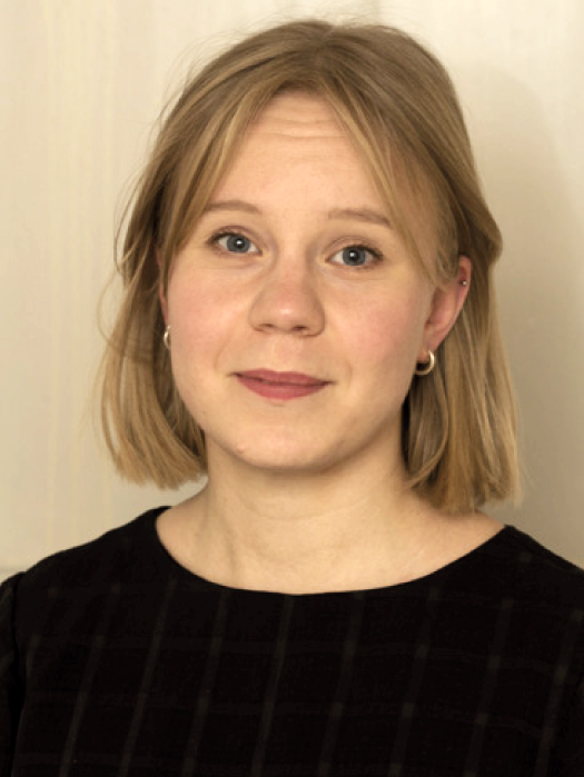 A woman with a black leather jacket in front of a birch tree. Photo.
