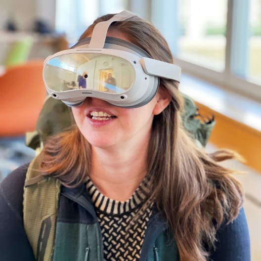 A woman with VR glasses and a backpack. Photo.