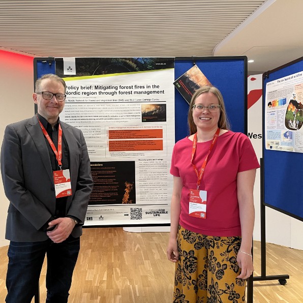 Inka Bohlin with a person next to her poster on conference. Photo. 